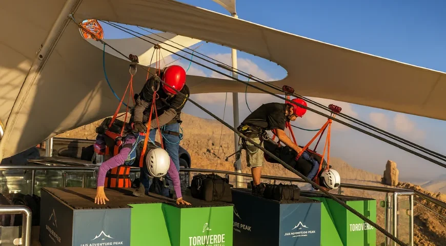 Adventure guides help riders secure zipline harnesses at Jebel Jais Adventure Peak launch platform